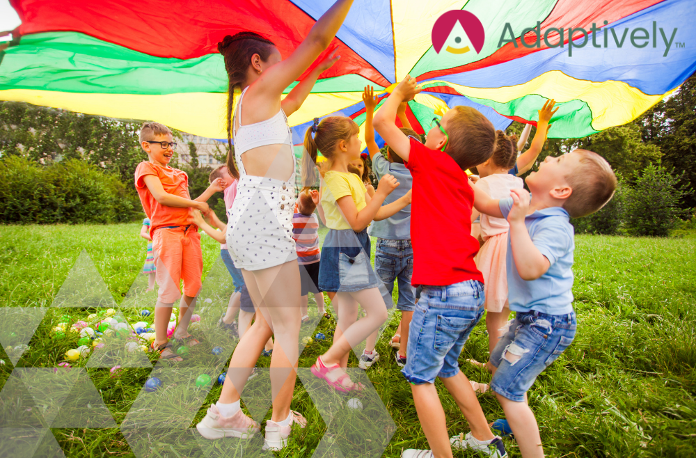 Group of kids playing under a parachute during Summer season
